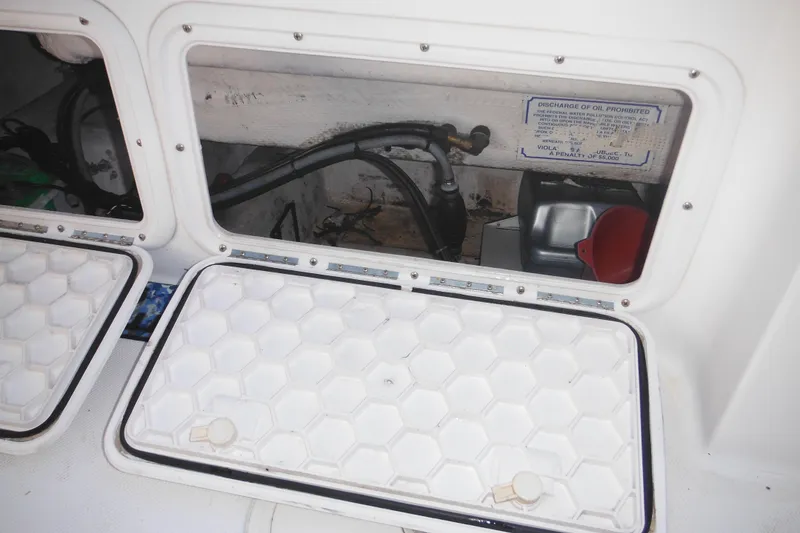 Slide: The Image of Storage compartment of a 2000 Pro-Line 23 Walkaround boat, featuring maintenance equipment. - 33