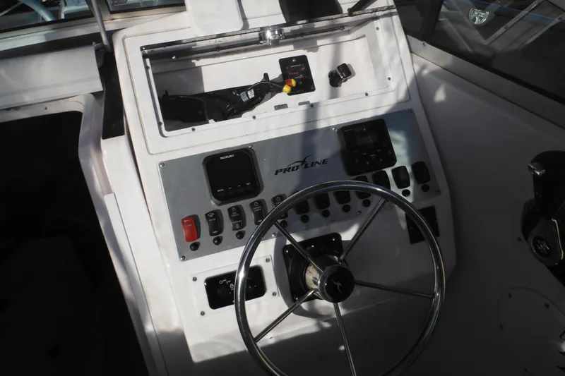 Slide: The Image of Steering console of a 2000 Pro-Line 23 Walkaround boat with controls and gauges. - 36