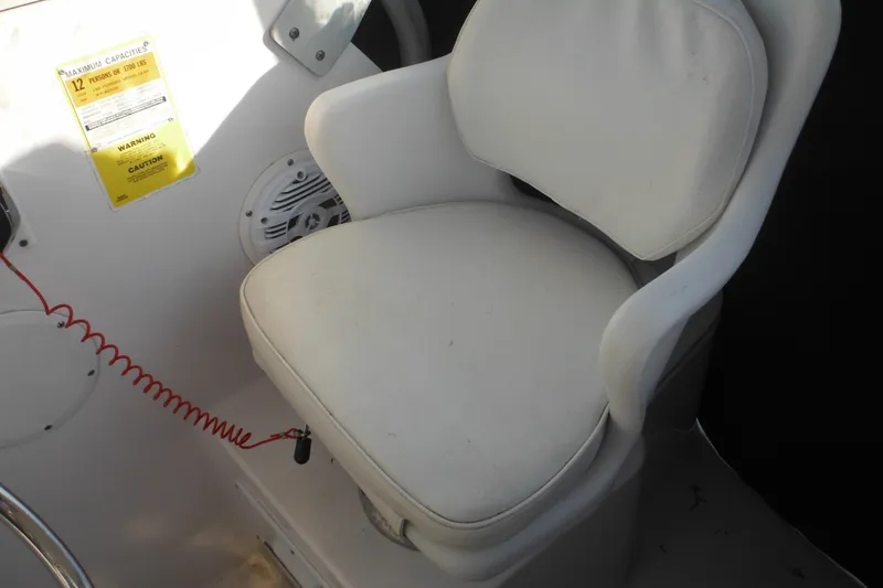 Slide: The Image of White captain's chair on 2000 Pro-Line 23 Walkaround boat, with safety label and speaker. - 39