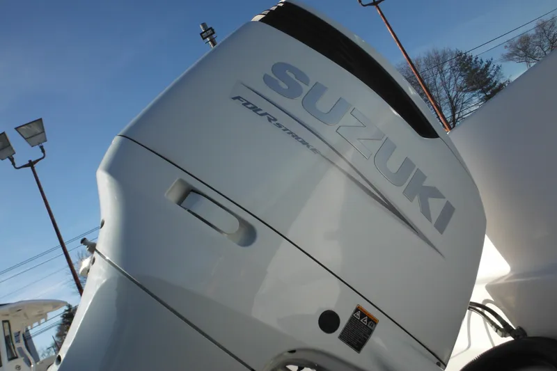 Slide: The Image of Suzuki outboard motor on 2000 Pro-Line 23 Walkaround boat, under clear blue sky. - 4