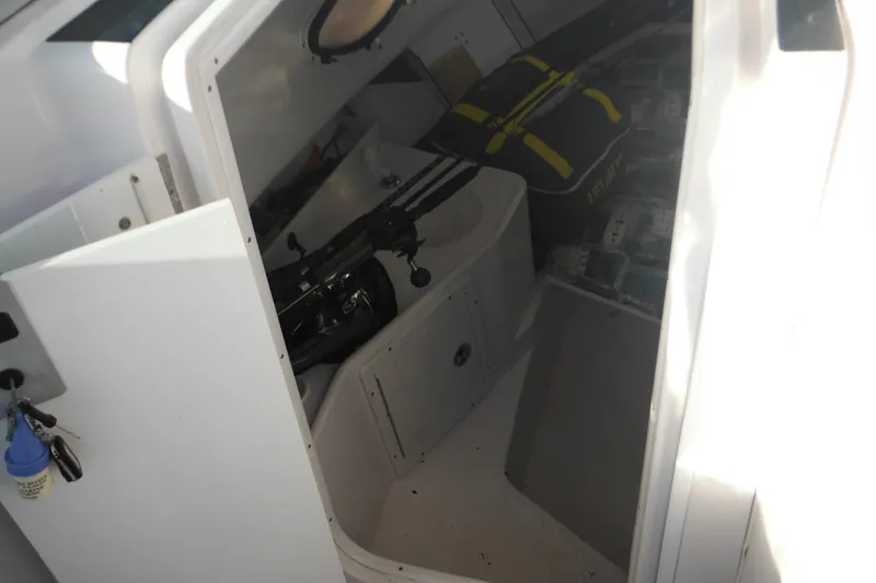 Slide: The Image of 2000 Pro-Line 23 Walkaround cabin interior with fishing gear and storage. - 41