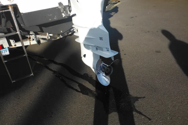 Slide: The Image of 2000 Pro-Line 23 Walkaround boat propeller and motor on pavement. - 8