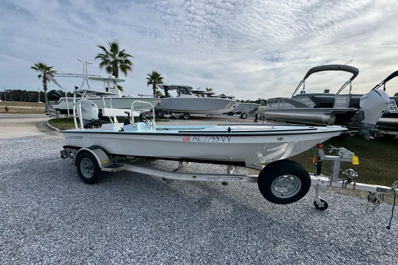 The Image of 2024 East Cape EVO 18 boat on trailer, parked with other boats, under cloudy sky. - 1