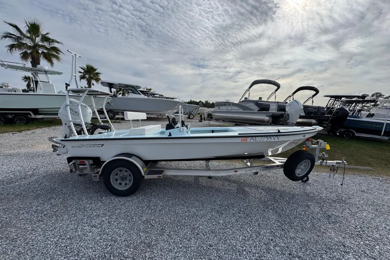 Slide: The Image of 2024 East Cape EVO 18 boat on trailer, parked outdoors under cloudy sky. - 2