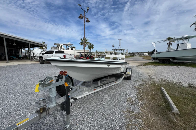 Slide: The Image of 2024 East Cape EVO 18 boat on trailer in marina setting under cloudy sky. - 10