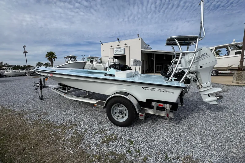 Slide: The Image of 2024 East Cape EVO 18 boat on trailer, displayed outdoors with Suzuki engine. - 14