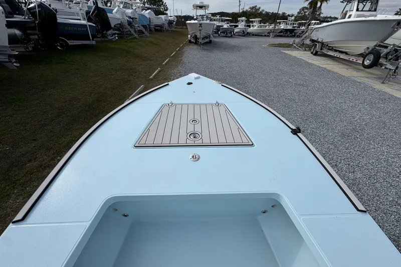 Slide: The Image of 2024 East Cape EVO 18 boat deck, light blue finish, in a marina setting. - 16