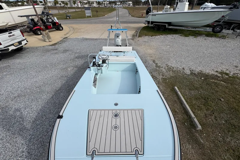 Slide: The Image of 2024 East Cape EVO 18 boat on gravel lot, showcasing sleek design and spacious deck. - 20