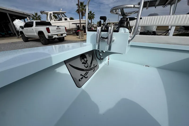 Slide: The Image of 2024 East Cape EVO 18 boat interior with steering wheel, rod holders, and skull design. - 22