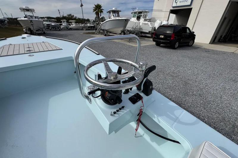 Slide: The Image of 2024 East Cape EVO 18 boat steering console in a marina setting. - 24