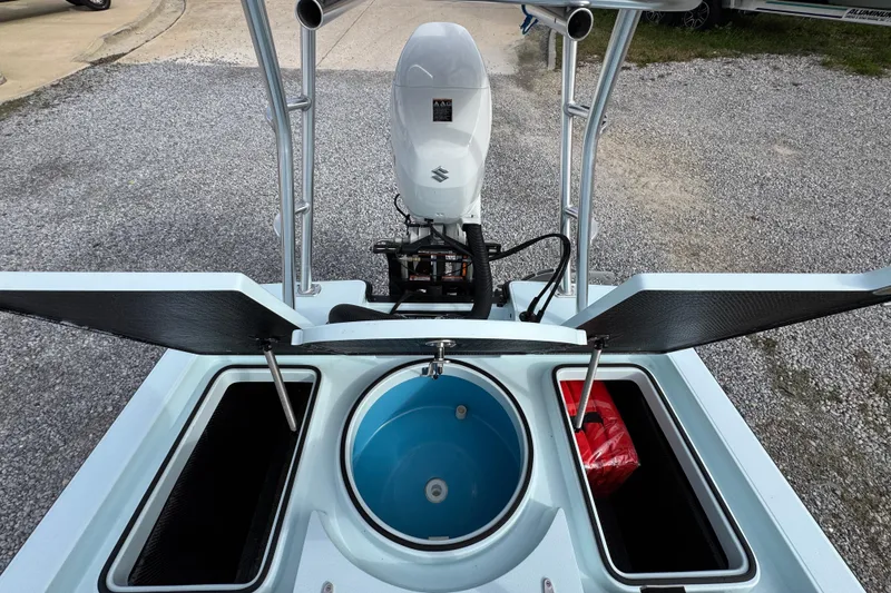 Slide: The Image of 2024 East Cape EVO 18 boat with open storage compartments and outboard motor. - 28