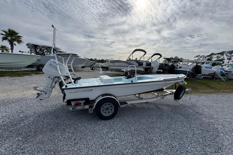 Slide: The Image of 2024 East Cape EVO 18 boat on trailer, parked in a marina under cloudy sky. - 3