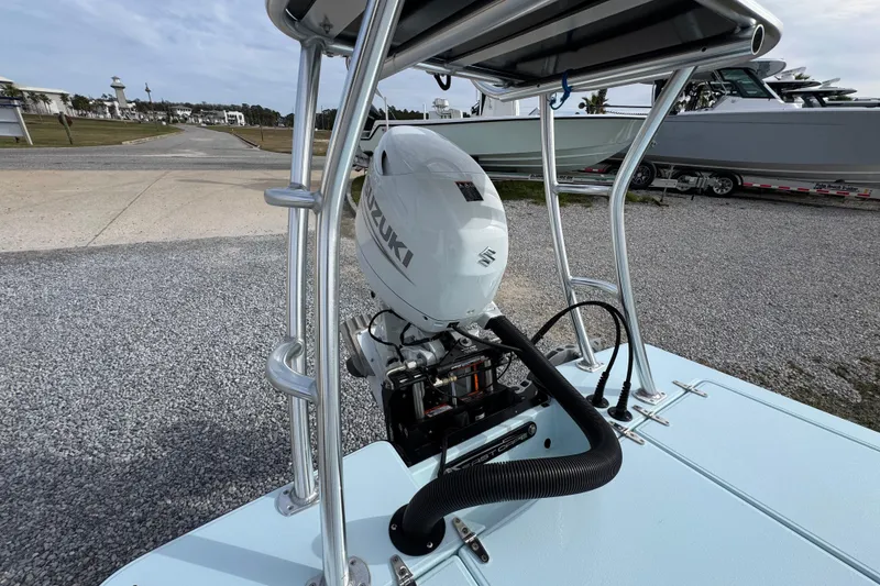 Slide: The Image of 2024 East Cape EVO 18 boat with Suzuki outboard motor, docked on gravel surface. - 31
