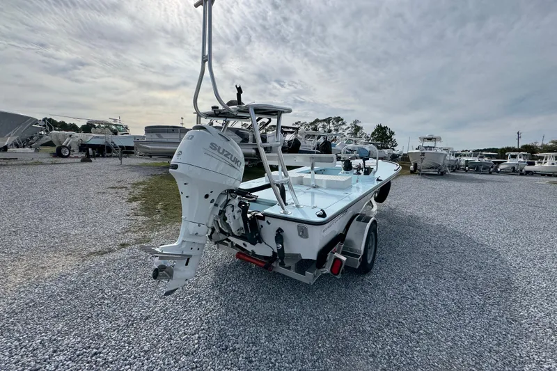 Slide: The Image of 2024 East Cape EVO 18 boat with Suzuki outboard motor on a trailer in a gravel lot. - 5