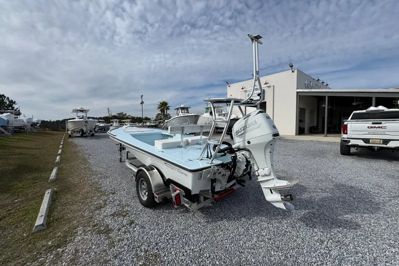 Slide: The Image of 2024 East Cape EVO 18 boat on trailer, parked near dealership under cloudy sky. - 7