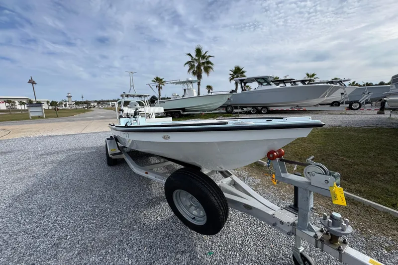 Slide: The Image of 2024 East Cape EVO 18 boat on trailer, parked outdoors under cloudy sky. - 8