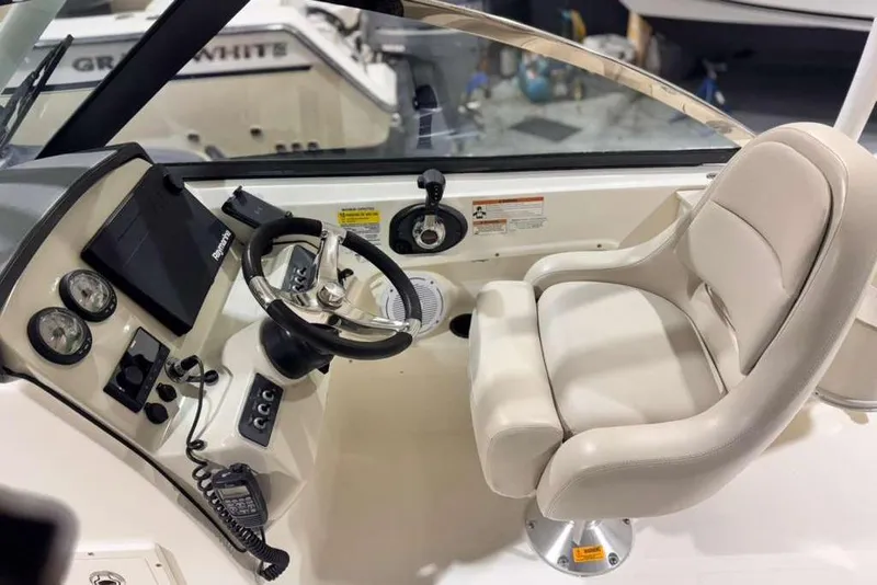 Slide: The Image of 2018 Boston Whaler 230 Vantage helm with steering wheel, gauges, and comfortable captain's chair. - 10