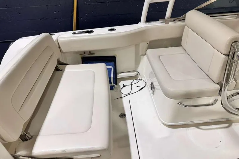 Slide: The Image of 2018 Boston Whaler 230 Vantage interior seating with white cushions and sleek design. - 12
