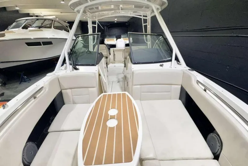 Slide: The Image of 2018 Boston Whaler 230 Vantage boat interior with seating and table in a showroom. - 4