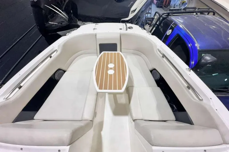 Slide: The Image of 2018 Boston Whaler 230 Vantage boat interior with cushioned seating and wooden table. - 5