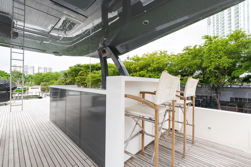 Slide: The Image of Luxury yacht deck with bar stools, Custom Line Navetta 33, 2018 model, docked near greenery. - 67