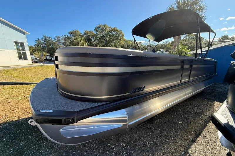 The Image of 2026 Viaggio Lago Z-B pontoon boat with sleek design and canopy, parked outdoors. - 0