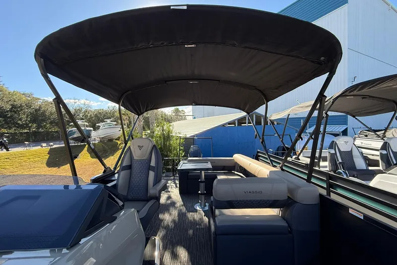 Slide: The Image of 2026 Viaggio Lago Z-B boat with canopy and seating, docked outdoors. - 13
