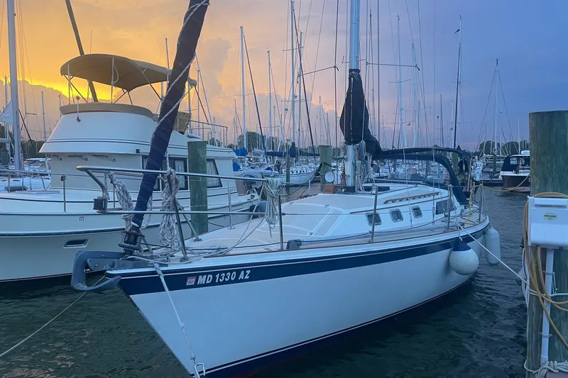 The Image of 1982 O'Day 34 sailboat docked at marina during sunset, with other boats nearby. - 0