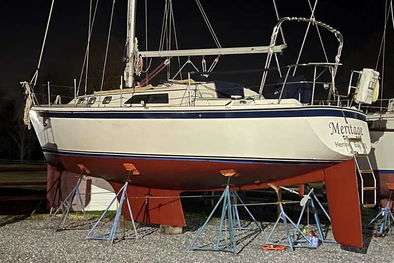 Slide: The Image of 1982 O'Day 34 sailboat on stands, nighttime view, red hull, white deck. - 10