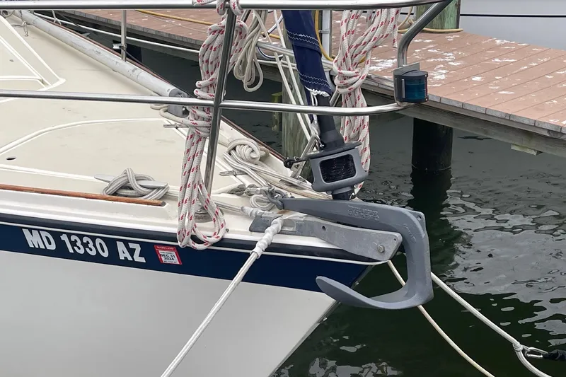 Slide: The Image of 1982 O'Day 34 sailboat docked, featuring anchor and ropes, registration MD 1330 AZ. - 12
