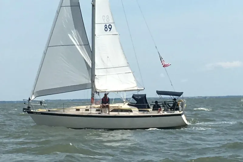 Slide: The Image of 1982 O'Day 34 sailboat navigating choppy waters under clear skies. - 2