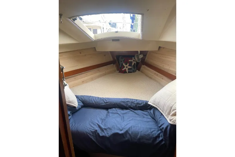Slide: The Image of Cozy cabin interior of 1982 O'Day 34 sailboat with bedding and starfish-themed decor. - 33