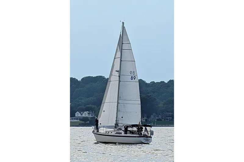 Slide: The Image of 1982 O'Day 34 sailboat on calm water near wooded shoreline. - 4