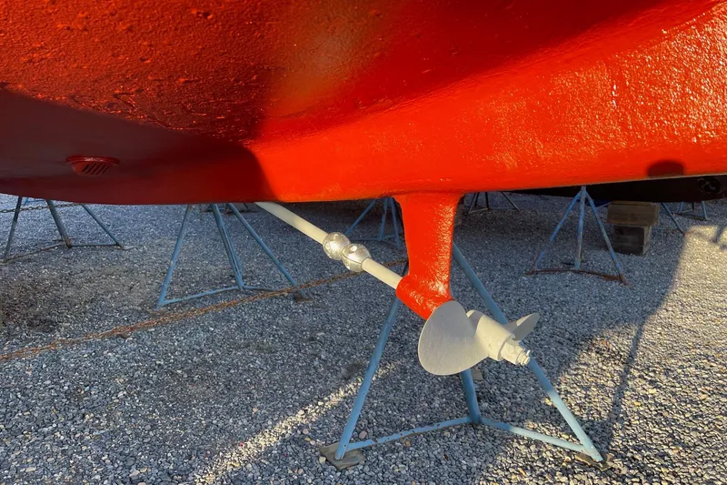 Slide: The Image of 1982 O'Day 34 sailboat hull and propeller on stands, painted bright red. - 7