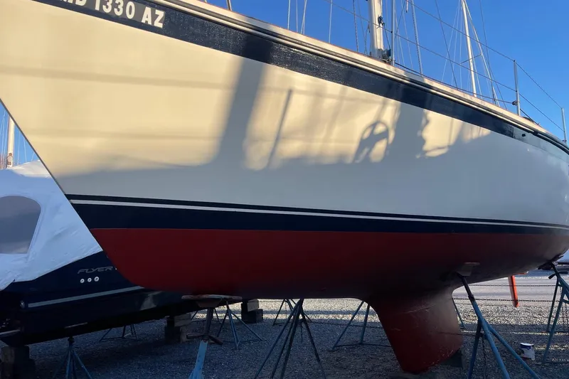 Slide: The Image of 1982 O'Day 34 sailboat on stands, showcasing hull and keel in a boatyard. - 9