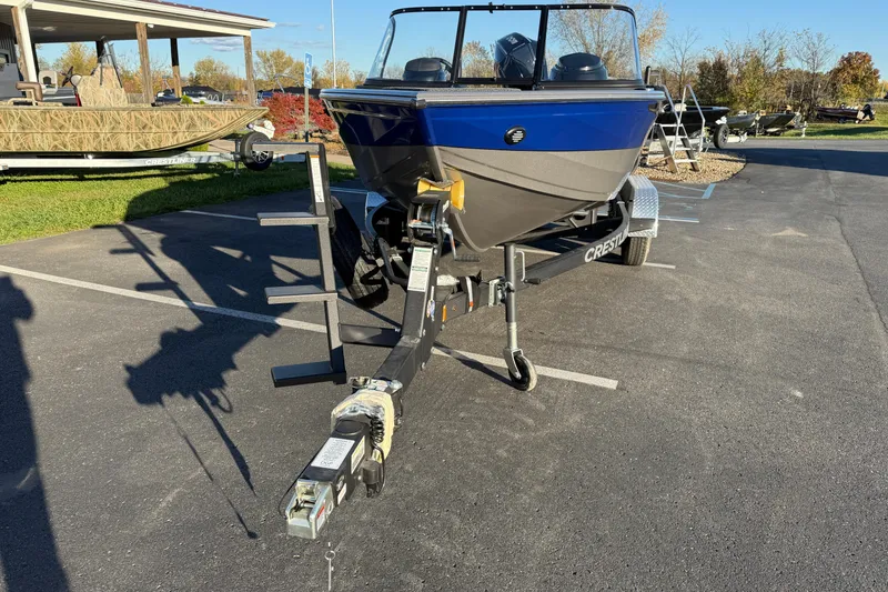 Slide: The Image of 2026 Crestliner 1850 Super Hawk boat on trailer in parking lot, sunny day. - 2