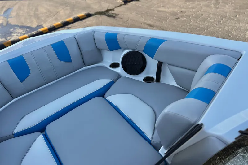 Slide: The Image of 2023 Malibu Wakesetter 21 LX interior with blue and gray seating, cup holders, and speaker. - 14