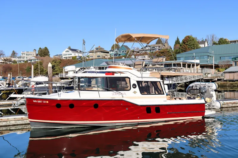 The Image of 2019 Ranger Tugs R-29 CB boat docked in a marina, featuring a vibrant red hull. - 0
