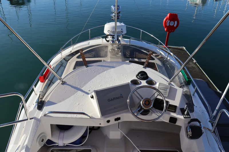 Slide: The Image of 2019 Ranger Tugs R-29 CB boat helm with Garmin navigation system, docked in calm waters. - 10
