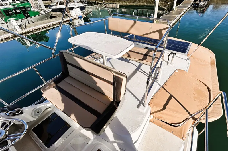 Slide: The Image of 2019 Ranger Tugs R-29 CB boat deck with seating and table at marina. - 11