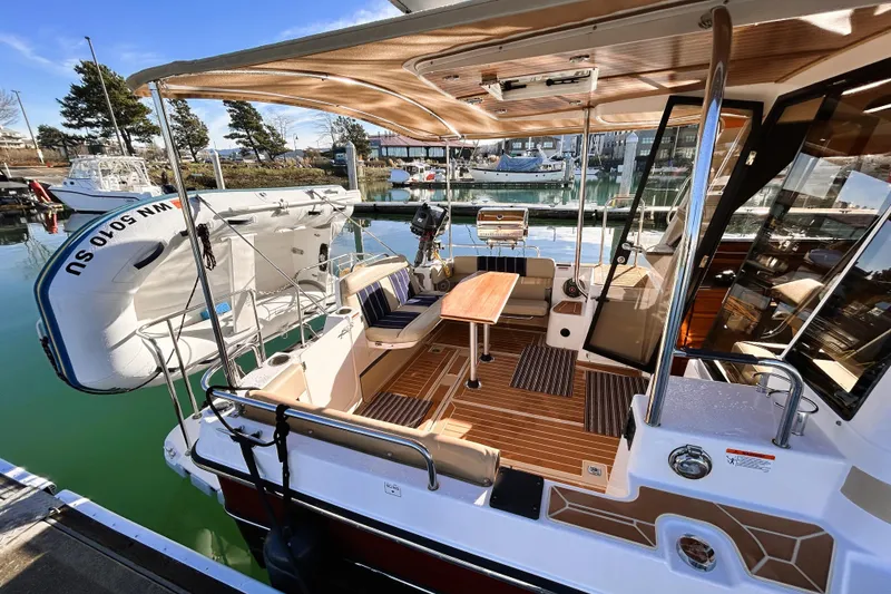 Slide: The Image of 2019 Ranger Tugs R-29 CB boat interior with seating and table at marina. - 14