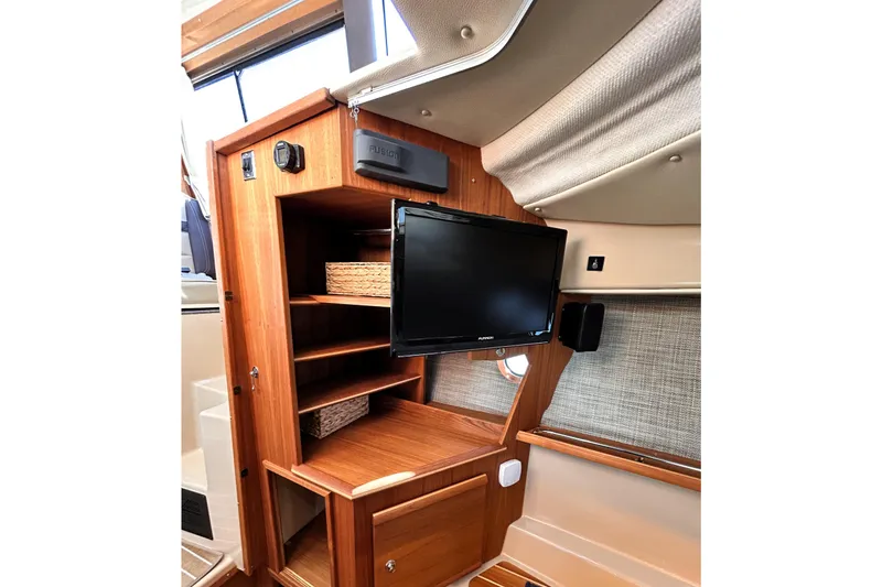 Slide: The Image of 2019 Ranger Tugs R-29 CB interior with wooden cabinetry and mounted TV. - 22