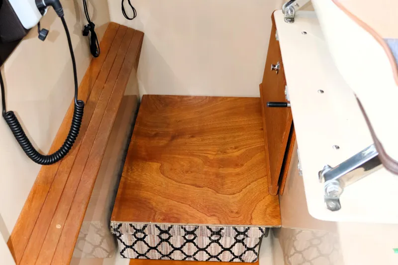 Slide: The Image of 2019 Ranger Tugs R-29 CB interior with wooden bench and storage compartment. - 25