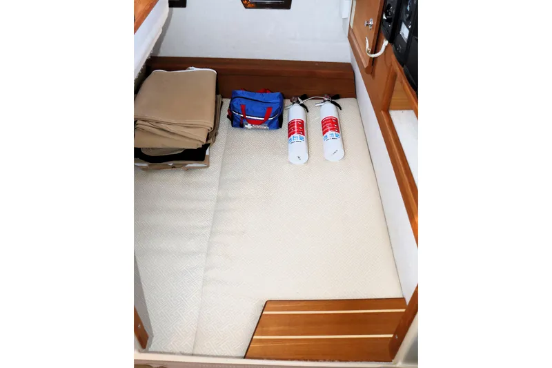 Slide: The Image of 2019 Ranger Tugs R-29 CB interior storage with fire extinguishers and folded items. - 27