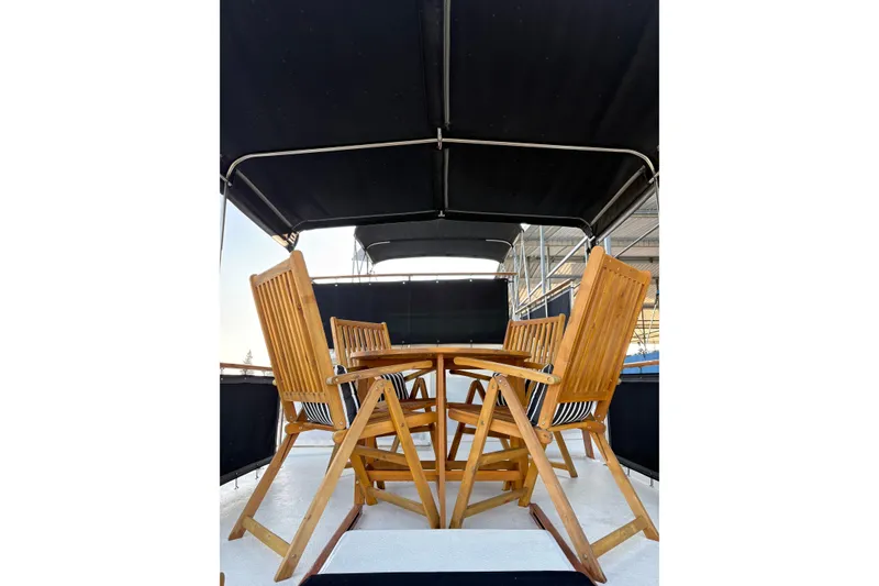 Slide: The Image of Outdoor seating on 1978 Californian 42 LRC yacht, featuring wooden chairs and table under canopy. - 11