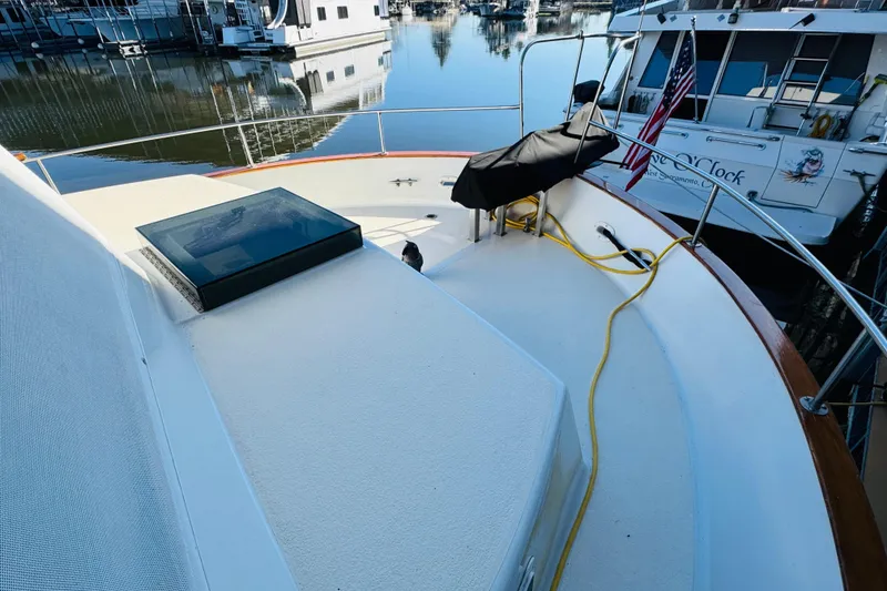 Slide: The Image of 1978 Californian 42 LRC yacht deck with marina view, featuring American flag and docked boats. - 12