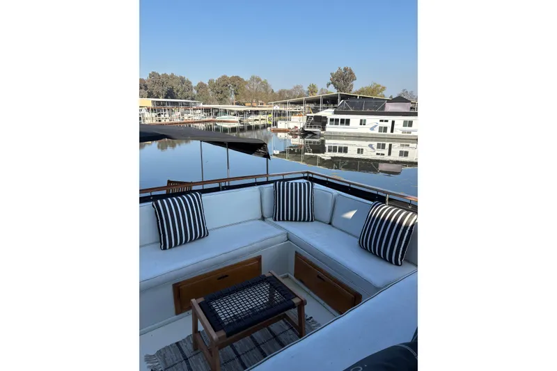 Slide: The Image of 1978 Californian 42 LRC yacht with striped cushions, docked in a serene marina setting. - 14