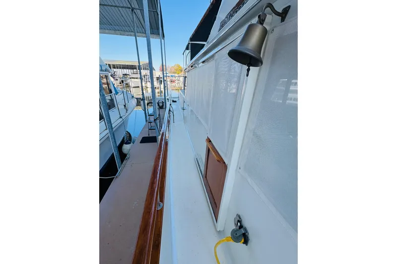 Slide: The Image of 1978 Californian 42 LRC yacht docked, featuring a bell and wooden railings. - 20