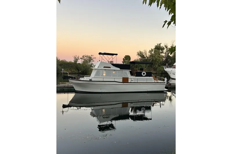 Slide: The Image of 1978 Californian 42 LRC yacht docked at sunset, reflecting on calm water. - 22