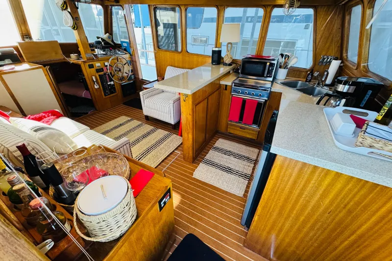 Slide: The Image of 1978 Californian 42 LRC yacht interior with wood finish, kitchen, and seating area. - 24